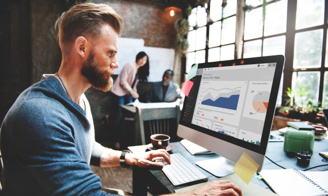 Male worker looks at analytical charts on a screen