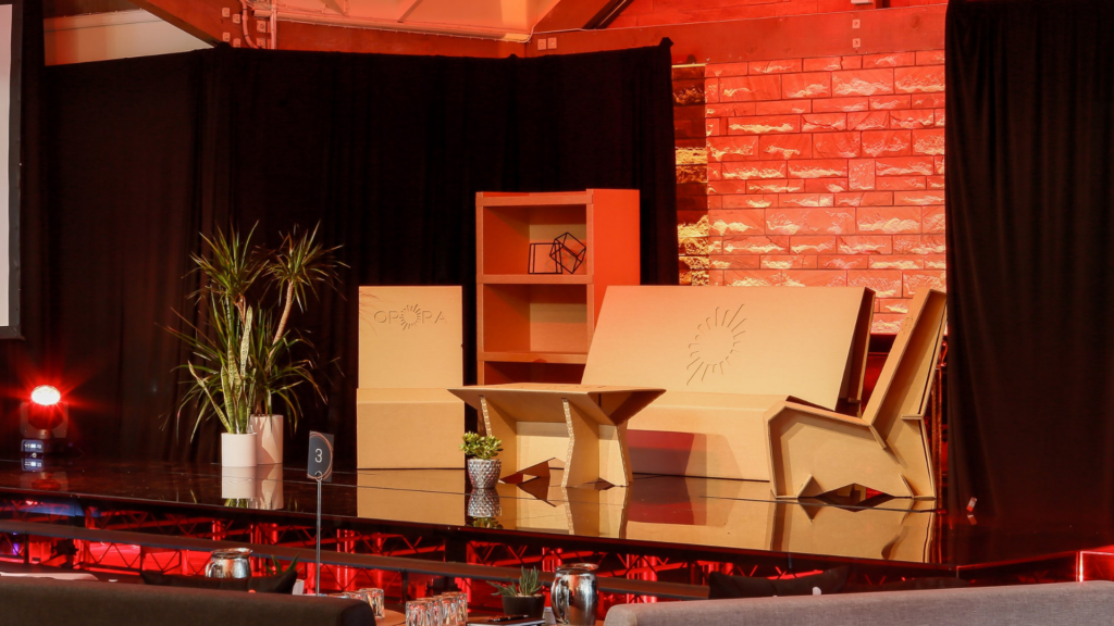 Reflective stage and accent lighting around custom recycled cardboard furniture